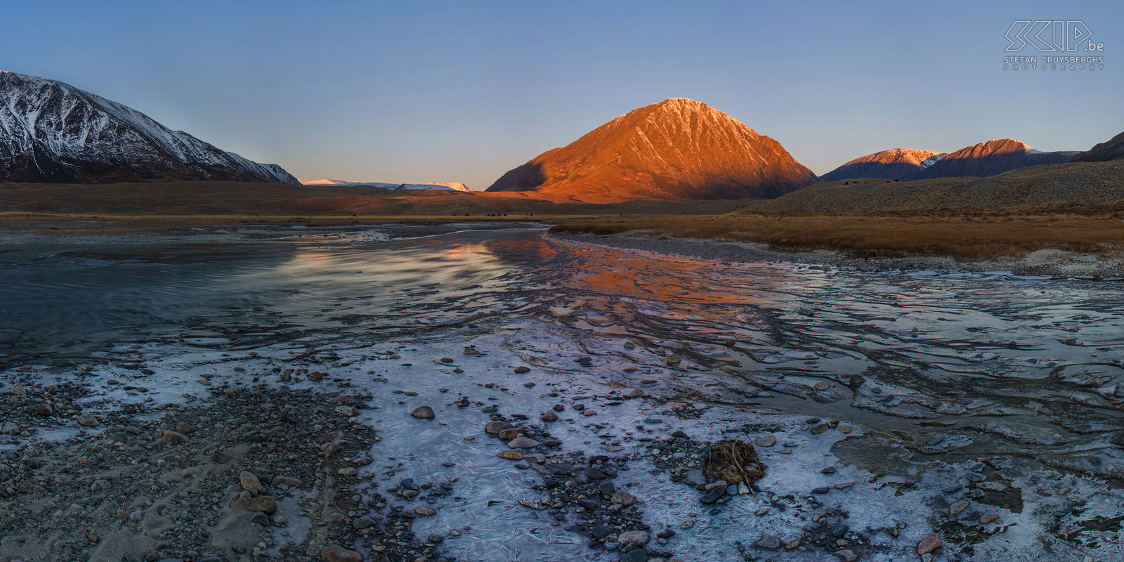 Altai Tavan Bogd - Zonsopgang Zonsopgang in het Altai gebergte in Mongolië dichtbij de grens met Rusland en China. Ik stond zeer vroeg op om wat foto’s met lange belichting van de rivier en het drijvende ijs te maken. De bergtoppen kregen een fantastische warme oranje kleur, maar het magische licht duurde slechts 5 minuten. Stefan Cruysberghs